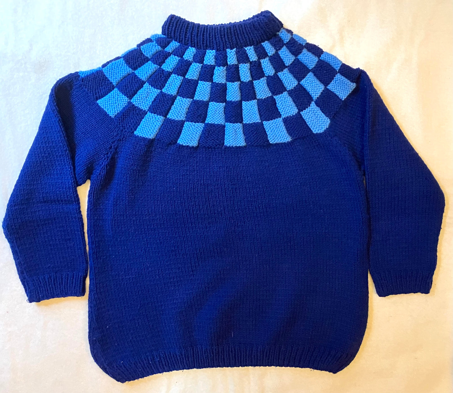 Vintage blue handknitted wool jumper with chequerboard pattern.