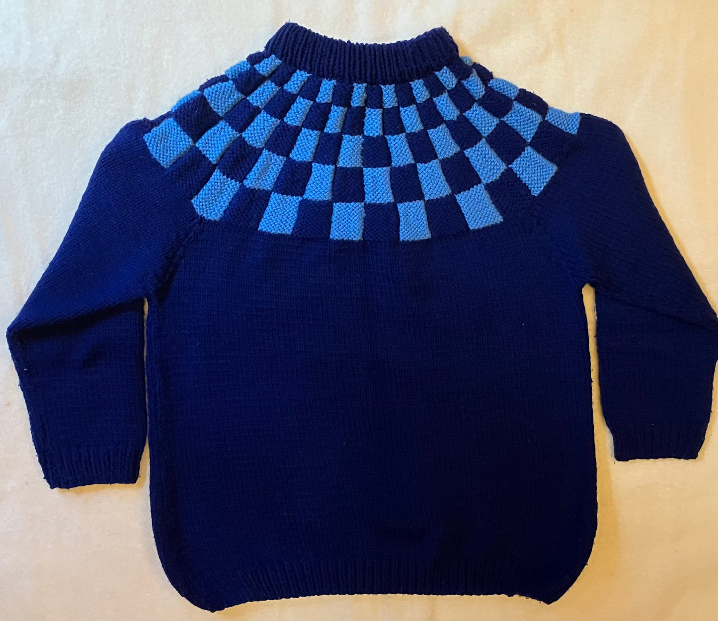 Vintage blue handknitted wool jumper with chequerboard pattern.